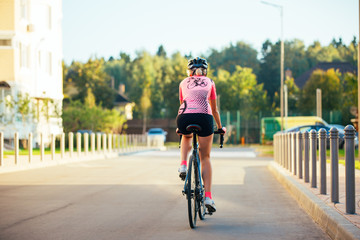 Obraz premium Picture of young woman in helmet on bike ride on summer day