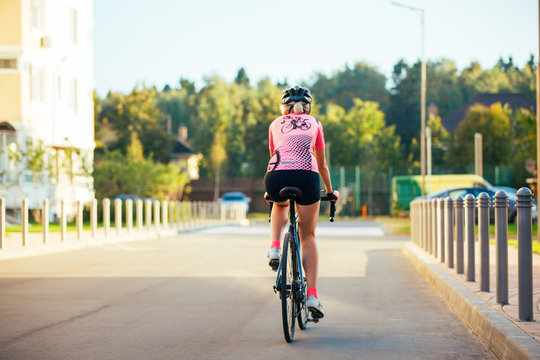 Picture of young woman in helmet on bike ride on summer day