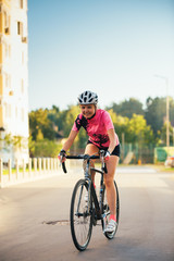 Fototapeta premium Picture of young woman in helmet on bike ride on summer day