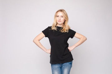 Studio portrait of unsatisfied young brunette caucasian woman with wavy hair in overall with...