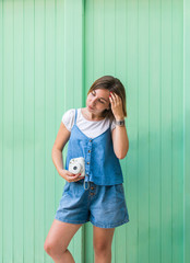Young woman with instant camera on the street.