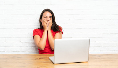 Young girl with pc in a table with surprise facial expression