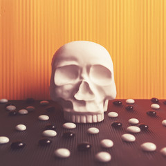 A decorative figure in the form of a human skull is on a yellow cardboard background. Black and...
