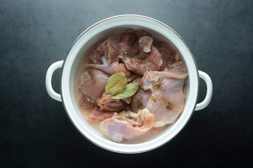 Raw chicken legs in pan, ready to coook. Top view over dark background.