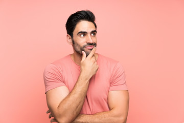 Handsome young man over isolated pink background thinking an idea