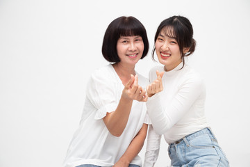 Happy Asian senior woman and daughter with mini heart sign together isolated on white background