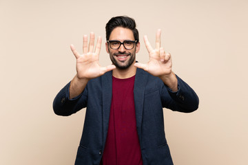 Handsome young man over isolated background counting eight with fingers