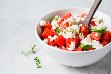 Watermelon, cucumber and feta cheese salad in white bowl, copy space.