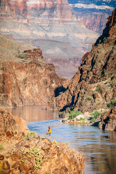 A woman stands above the Colorado River at Mile 136 of a rafting trip, Grand Canyon National Park, Arizona, USA