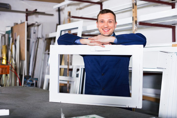 Professional labour with finished PVC profiles and windows at factory