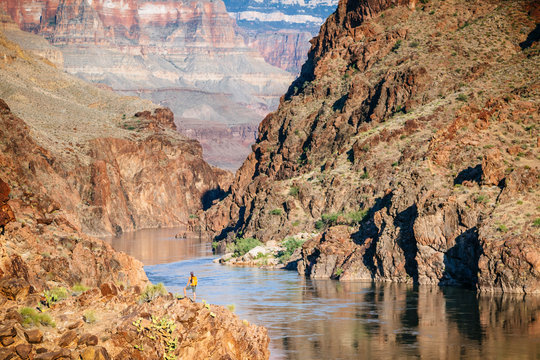 A woman stands above the Colorado River at Mile 136 of a rafting trip, Grand Canyon National Park, Arizona, USA