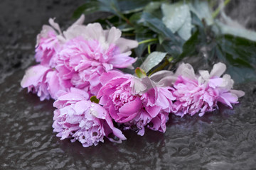 Wet bouquet of flowers lies in the mud after heavy rain