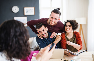 A group of young friends with laptop indoors, house sharing concept.