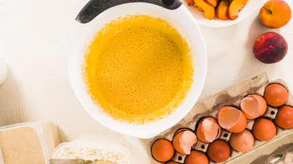 Baking Cake with Dough Recipe Ingredients and Fresh Peaches. Top View, White Background