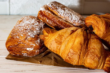 French croissants and puffs on craft paper on a white background.