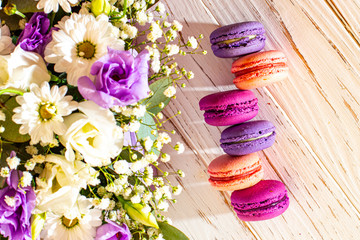 Romantic bouquet of flowers and macaroons of a lilac shade on a white background.