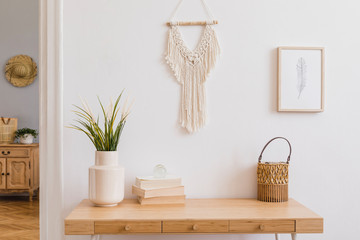 Stylish and modern boho interior of living room with mock up photo frames, flowers in vase, wooden...