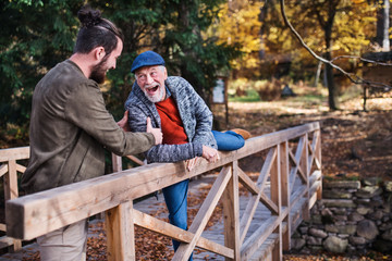 Senior father and his son walking in nature, having fun.