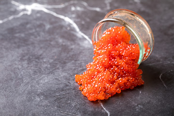 Salmon  Red Caviar in a white plate on a dark background. Healthy Food Concept. Snack.Copy space for Text.Seafood.