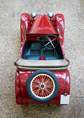 Fototapeta premium The above view of vintage car with spare wheel. The red classic car with classical wheel on rear.