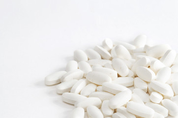 Fototapeta na wymiar Group of white vitamin pills on white backgrond