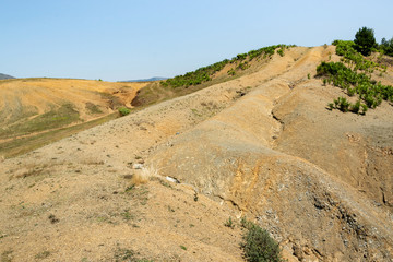 Albanian nature landscape. Sandy hills with rainwater sign on the ground.