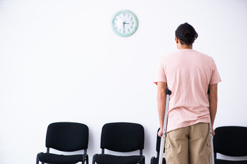 Young injured man waiting for his turn in hospital hall