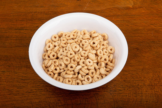 A breakfast of toasted oat ceral on a wood table.
