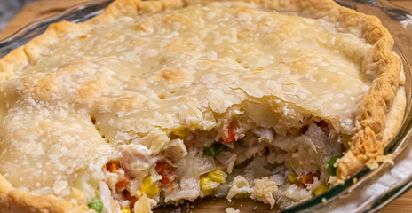A hot, home made Chicken Pot Pie with brown crust and serving missing