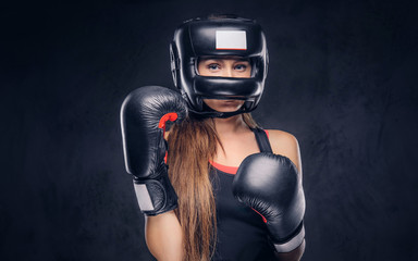 Brave woman is ready to fight, she is wearing boxer gloves and protective helmet.