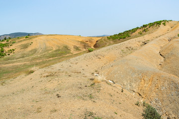 Albanian nature landscape. Sandy hills with rainwater sign on the ground.