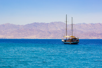 cruise tourism on a sea summer season scenic landscape picture of vintage wooden ship floating on...