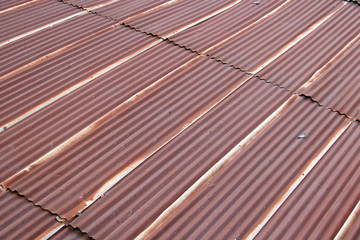 A red corrugated roof at diagonal view. Tin plates on the roof of building.