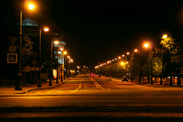 car traffic on a night city street lit by lanterns