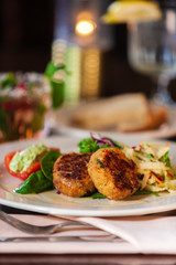 Crab cake appetizer on a white plate.