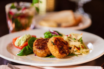 Crab cake appetizer on a white plate.