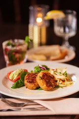 Crab cake appetizer on a white plate.