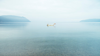 A woman is diving from a floating platform in Lake Taupo, Waikato, New Zealand