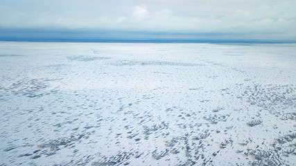 Aerial view of white winter frozen lake  from above. bird's eye, drone shot. amazing natural background