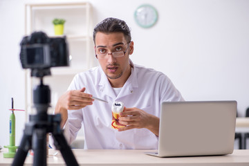 Young male doctor dentist recording video for his blog