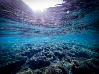 Underwater view of the seabed in San Lorenzo beach, in the southern Sicily, Italy. The shot is takend during a sunny summer day, with rays of light coming inside the water