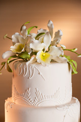 Close-up of a white wedding cake with white flowers.