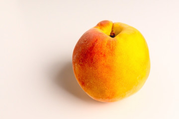 Ripe peach close-up on a white table