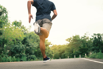 Man athlete runner feet running on the road. Concepts jogging outdoors.