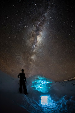 New Zealand, South Island, Otago. A man has just finished building an igloo as night falls.