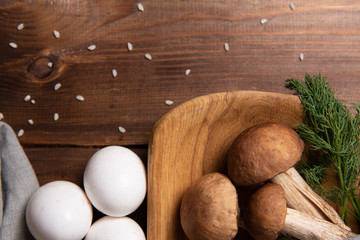 wooden tray with porcini mushrooms on a wooden table. Ingredients before cooking. Copy space