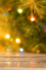 Blurred background of a Christmas tree with burning lights.
