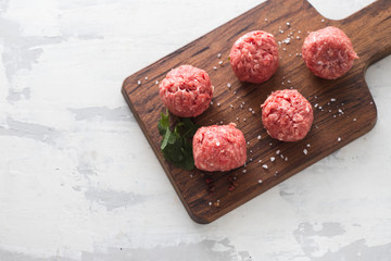 raw meatballs with pepper and salt in plastic box