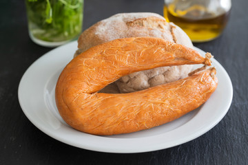 typical portuguese sausage Farinheira with bread on white plate  on ceramic background