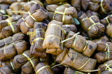 Deep fried chicken wrapped in green pandan leaves at street food market in Thailand. Thai food concept